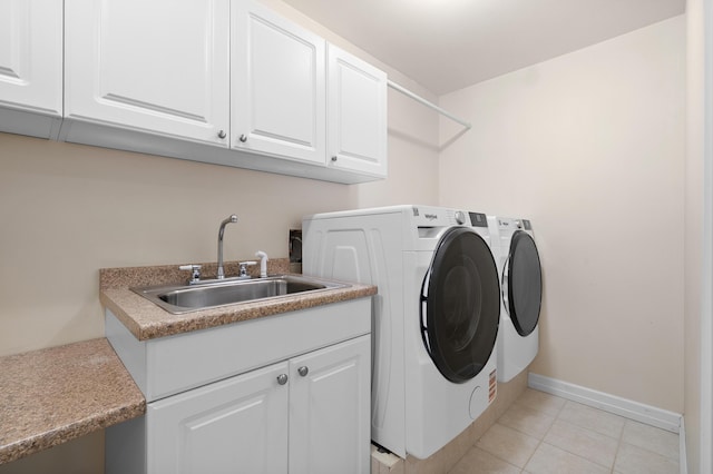 3229 Nighthawk Ln, Battle Creek, MI 49015 - laundry area featuring washing machine and dryer, cabinet space, and light tile patterned floors
