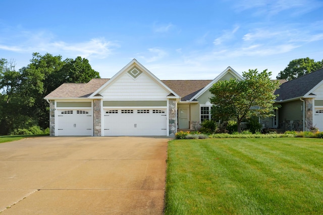 3229 Nighthawk Ln, Battle Creek, MI 49015 - view of front of home with a garage, concrete driveway, a front yard, and stone siding