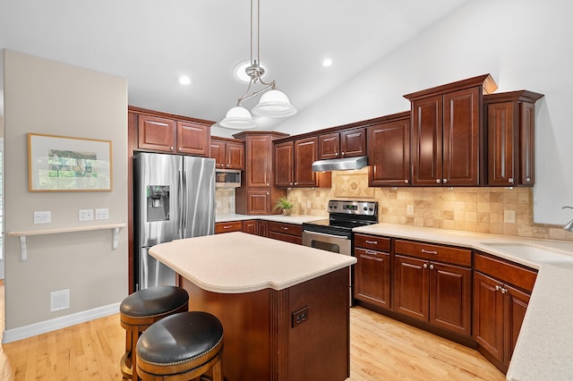 3229 Nighthawk Ln, Battle Creek, MI 49015 - kitchen featuring appliances with stainless steel finishes, under cabinet range hood, light countertops, tasteful backsplash, and lofted ceiling