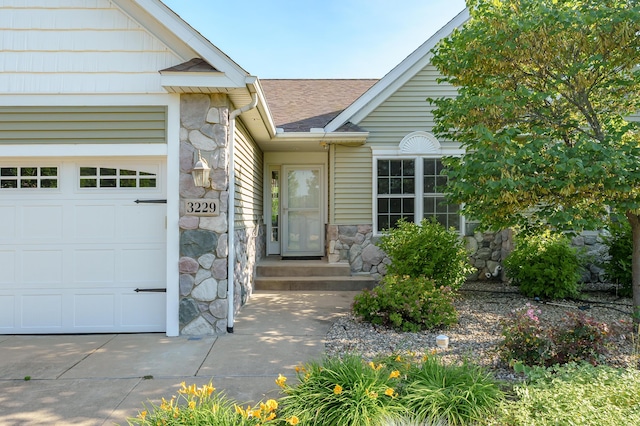3229 Nighthawk Ln, Battle Creek, MI 49015 - doorway to property featuring stone siding, an attached garage, and a shingled roof