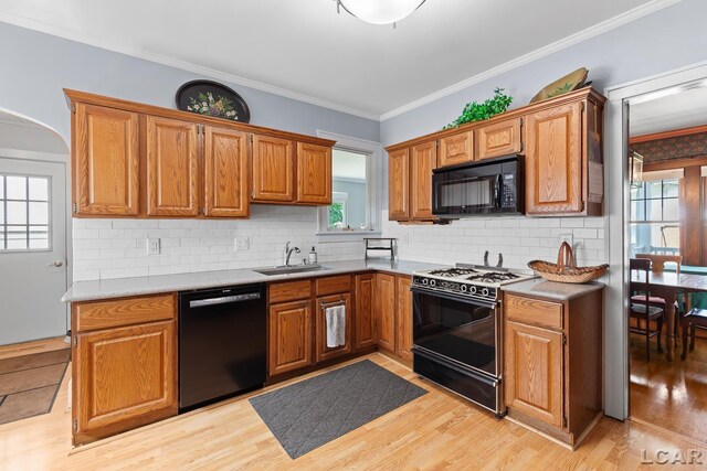 1044 Michigan Ave, Adrian, MI 49221 - kitchen featuring black appliances, tasteful backsplash, light wood-style flooring, ornamental molding, and brown cabinets
