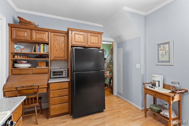 1044 Michigan Ave, Adrian, MI 49221 - kitchen featuring freestanding refrigerator, light wood-style floors, ornamental molding, decorative backsplash, and a desk