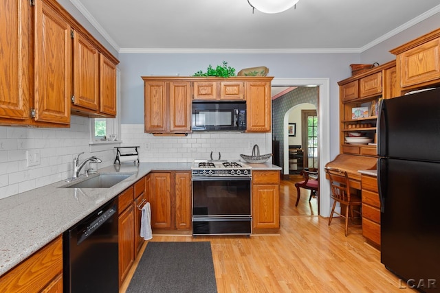 1044 Michigan Ave, Adrian, MI 49221 - kitchen featuring black appliances, arched walkways, tasteful backsplash, light wood-style flooring, and crown molding