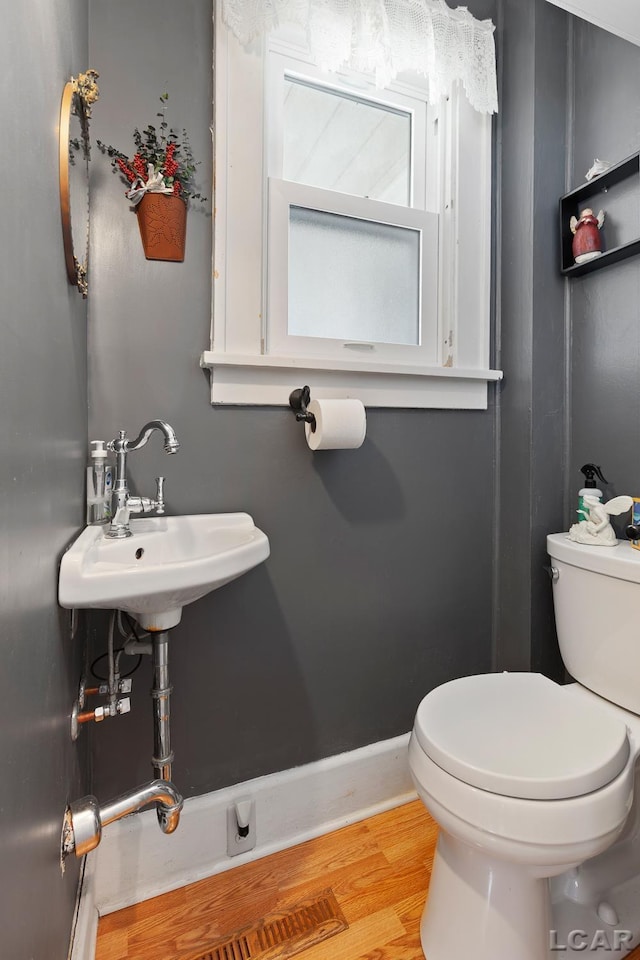 1044 Michigan Ave, Adrian, MI 49221 - half bathroom with wood finished floors and toilet