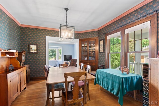 1044 Michigan Ave, Adrian, MI 49221 - dining space with wallpapered walls, light wood-type flooring, ornamental molding, and a chandelier