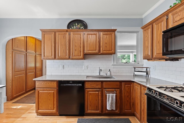 1044 Michigan Ave, Adrian, MI 49221 - kitchen with black appliances, backsplash, light wood-style floors, light countertops, and ornamental molding