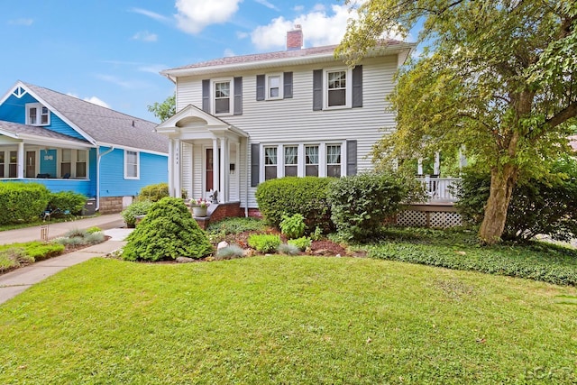 1044 Michigan Ave, Adrian, MI 49221 - view of front of house featuring a chimney, a front lawn, and a wooden deck