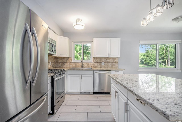 2375 Pontiac Trl, Ann Arbor, MI 48105 - kitchen with stainless steel appliances, backsplash, white cabinets, and light stone counters