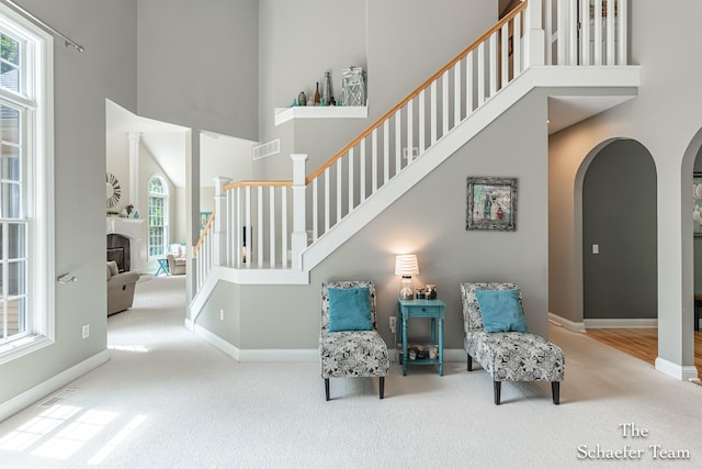 5264 Deverman Ct NE, Lowell, MI 49331 - living area with a towering ceiling, carpet, healthy amount of natural light, arched walkways, and stairway
