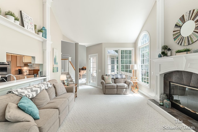 5264 Deverman Ct NE, Lowell, MI 49331 - carpeted living area featuring high vaulted ceiling, a tiled fireplace, and stairway