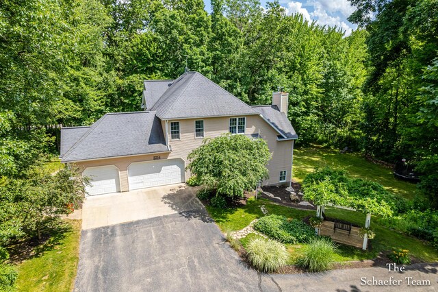 5264 Deverman Ct NE, Lowell, MI 49331 - view of front of house featuring driveway, a garage, a chimney, and roof with shingles