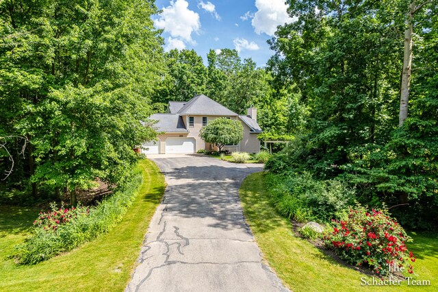 5264 Deverman Ct NE, Lowell, MI 49331 - view of front of house featuring driveway and a chimney
