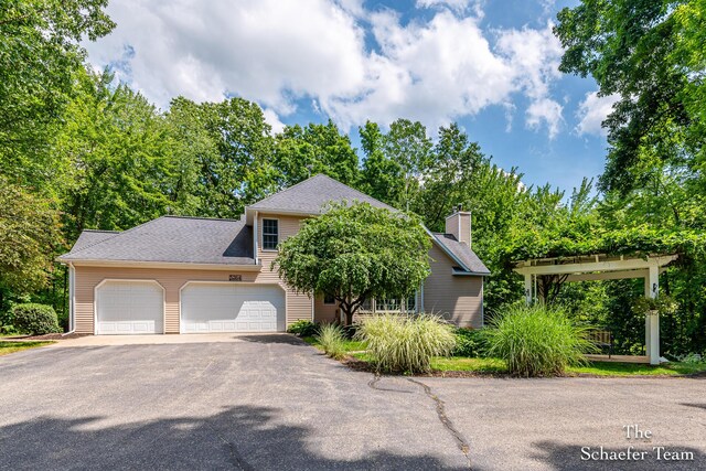 5264 Deverman Ct NE, Lowell, MI 49331 - obstructed view of property with driveway, a garage, and a chimney