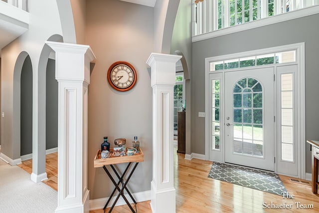 5264 Deverman Ct NE, Lowell, MI 49331 - foyer featuring a towering ceiling, decorative columns, light wood-type flooring, and arched walkways