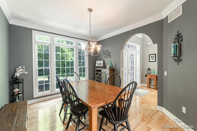 5264 Deverman Ct NE, Lowell, MI 49331 - dining area featuring arched walkways, plenty of natural light, light wood-style flooring, crown molding, and a chandelier