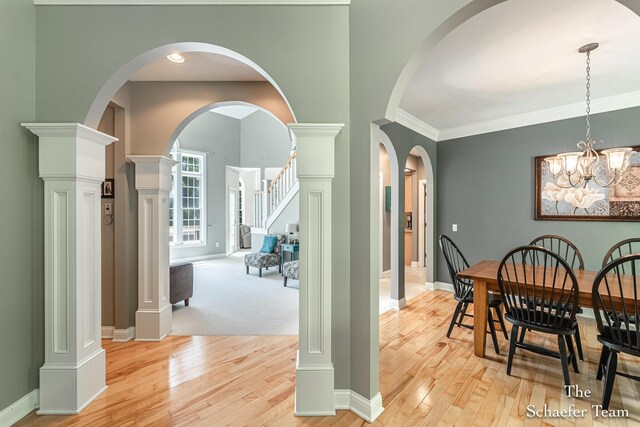 5264 Deverman Ct NE, Lowell, MI 49331 - dining area with light wood-style flooring, stairs, a chandelier, and ornamental molding