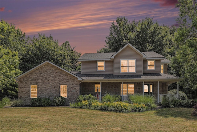 4166 Grandwood Cir, Saint Joseph, MI 49085 - view of front of house with brick siding, a front lawn, a porch, and a shingled roof
