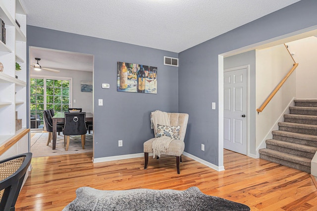 4166 Grandwood Cir, Saint Joseph, MI 49085 - living area with light wood finished floors, stairs, ceiling fan, and a textured ceiling