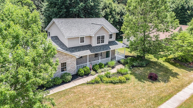 4166 Grandwood Cir, Saint Joseph, MI 49085 - traditional-style home with a porch, roof with shingles, a front lawn, and stone siding