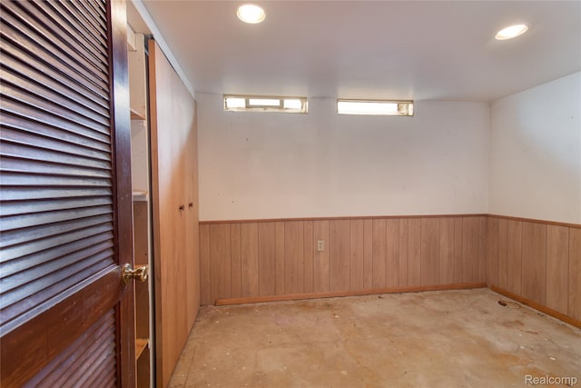 9892 Wheeler St, Van Buren, MI 48111 - empty room with wainscoting, wooden walls, concrete floors, and recessed lighting