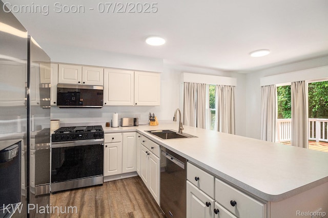 3708 Eaton Gate Ln, Auburn Hills, MI 48326 - kitchen with stainless steel appliances, a peninsula, dark wood-type flooring, light countertops, and white cabinetry
