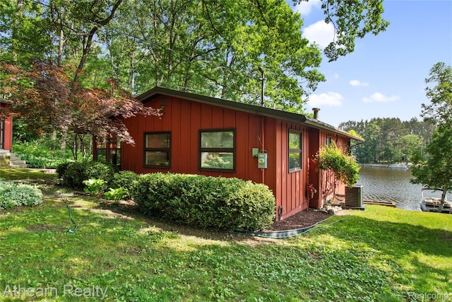 6600 W Shore Dr, Weidman, MI 48893 - view of front of property featuring board and batten siding, a front lawn, and a water view
