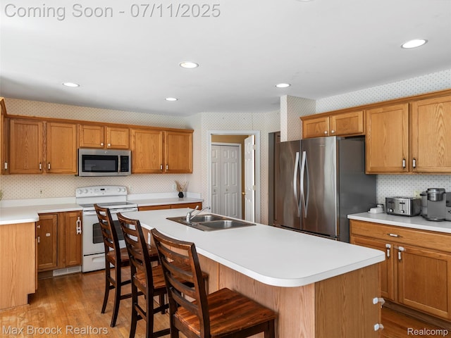 39104 Devonshire Ct, Harrison Township, MI 48045 - kitchen featuring stainless steel appliances, wallpapered walls, light countertops, brown cabinets, and recessed lighting