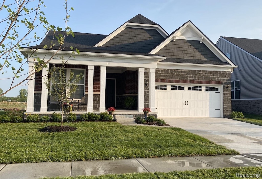 5164 Barnes Rd, Canton, MI 48188 - view of front of property with an attached garage, concrete driveway, a porch, a front lawn, and stone siding