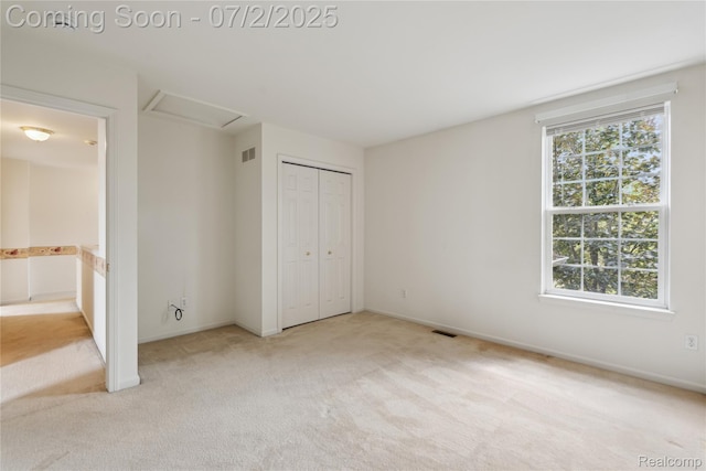 10074 Pond View Trl, Holly, MI 48442 - unfurnished bedroom with light colored carpet, attic access, a closet, and ensuite bath