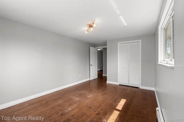 1593 Parke St, Rochester Hills, MI 48307 - unfurnished bedroom with a closet, dark wood-type flooring, and a baseboard radiator