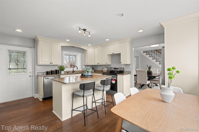 1593 Parke St, Rochester Hills, MI 48307 - kitchen with stainless steel appliances, a kitchen island, dark wood-style floors, recessed lighting, and a breakfast bar area