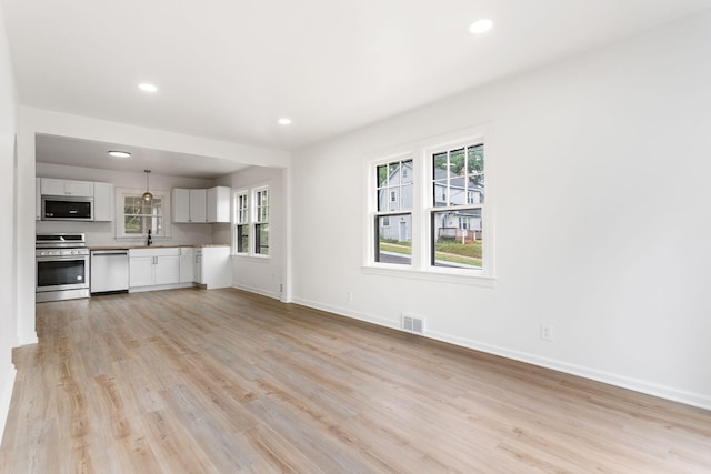 1680 Kalamazoo Ave SE, Grand Rapids, MI 49507 - unfurnished living room with light wood-type flooring, plenty of natural light, and recessed lighting