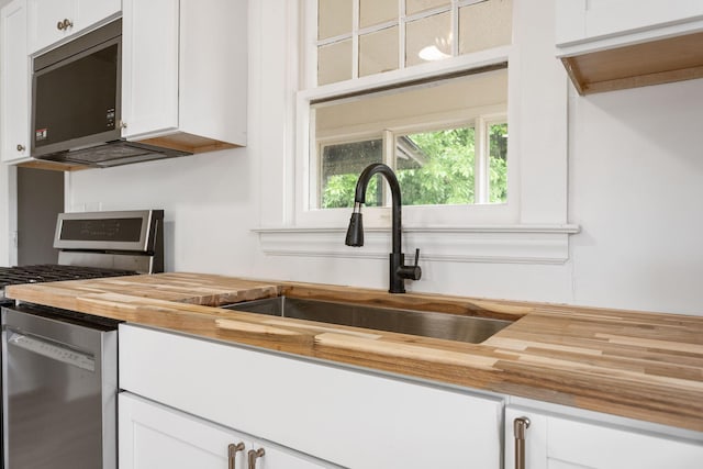 1680 Kalamazoo Ave SE, Grand Rapids, MI 49507 - kitchen with butcher block countertops, stainless steel appliances, and white cabinets