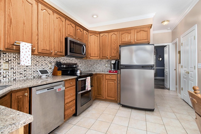 4673 Chasemoor Dr, Portage, MI 49024 - kitchen with stainless steel appliances, ornamental molding, light stone counters, light tile patterned floors, and brown cabinetry