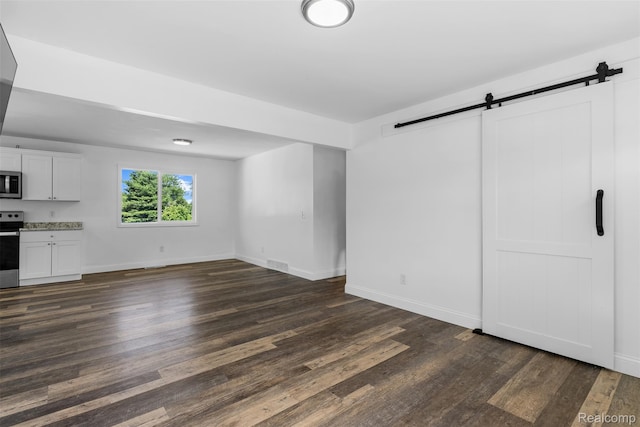 7900 Wiggins Rd, Howell, MI 48855 - unfurnished living room featuring a barn door and dark wood finished floors