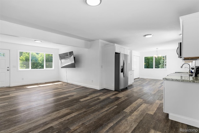 7900 Wiggins Rd, Howell, MI 48855 - unfurnished living room with dark wood-style flooring and a chandelier