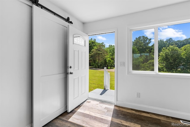 7900 Wiggins Rd, Howell, MI 48855 - entrance foyer with a barn door and dark wood-style flooring