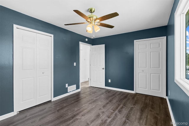 7900 Wiggins Rd, Howell, MI 48855 - unfurnished bedroom with dark wood-style floors, a closet, and a ceiling fan