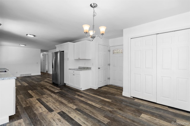 7900 Wiggins Rd, Howell, MI 48855 - kitchen featuring stainless steel fridge, white cabinetry, dark wood-type flooring, a chandelier, and decorative light fixtures