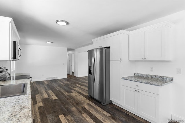 7900 Wiggins Rd, Howell, MI 48855 - kitchen featuring appliances with stainless steel finishes, dark wood-type flooring, white cabinets, and light stone countertops