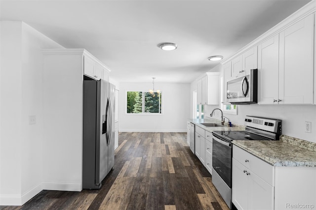 7900 Wiggins Rd, Howell, MI 48855 - kitchen featuring stainless steel appliances, dark wood finished floors, white cabinets, and a chandelier