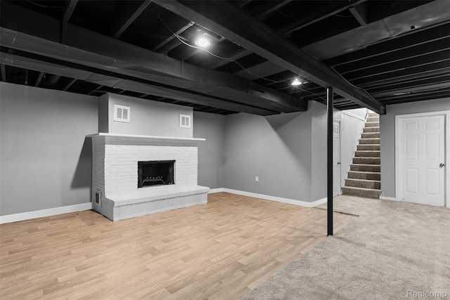 7900 Wiggins Rd, Howell, MI 48855 - finished basement with stairway, wood finished floors, and a fireplace