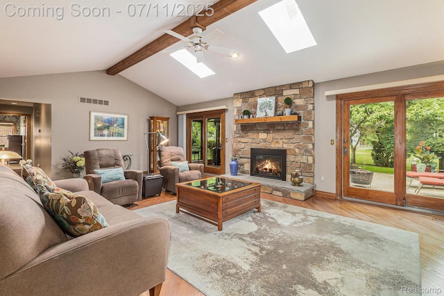 5131 Standish Dr, Troy, MI 48085 - living room featuring a skylight, wood finished floors, a stone fireplace, and a ceiling fan