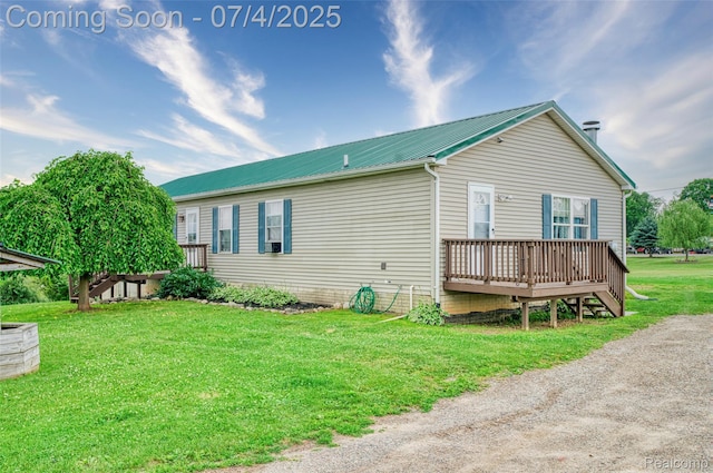5771 Milett Rd, Fowlerville, MI 48836 - view of side of property featuring a deck, a lawn, and a metal roof