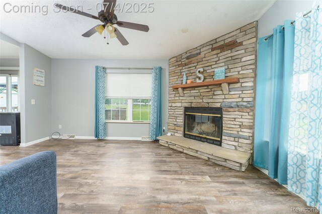 5771 Milett Rd, Fowlerville, MI 48836 - unfurnished living room with healthy amount of natural light, wood finished floors, a fireplace, and a ceiling fan