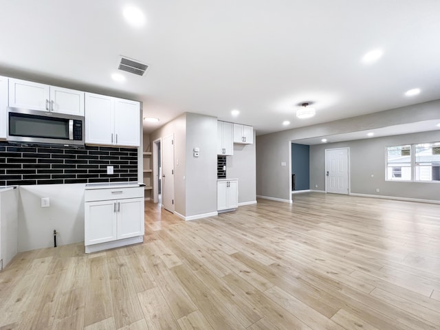 20283 Lancaster St, Harper Woods, MI 48225 - kitchen featuring stainless steel microwave, white cabinets, recessed lighting, open floor plan, and light wood finished floors