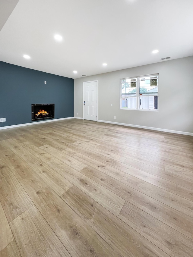 20283 Lancaster St, Harper Woods, MI 48225 - unfurnished living room with light wood finished floors, a warm lit fireplace, and recessed lighting
