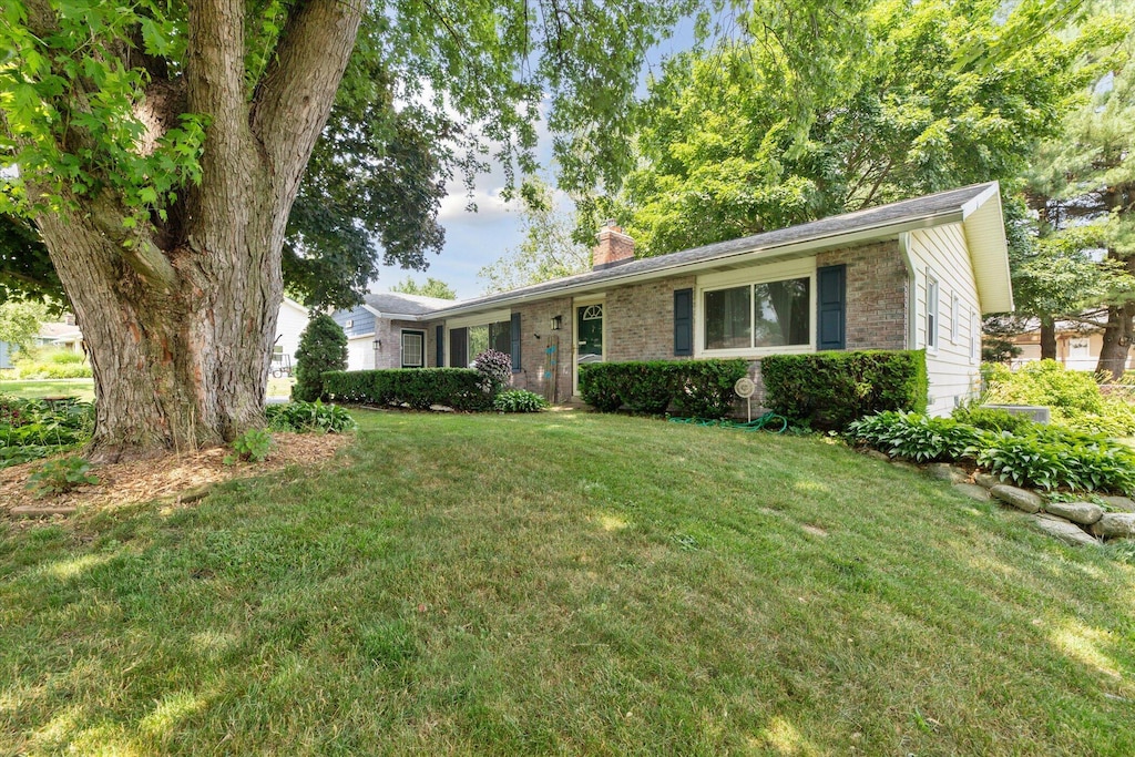 5130 Patland Dr, Kalamazoo, MI 49009 - ranch-style house with a chimney, a front lawn, and brick siding