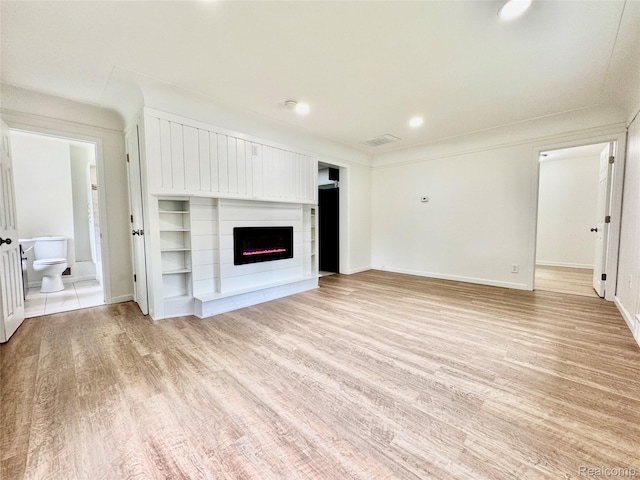 4915 Clarkston Rd, Clarkston, MI 48348 - unfurnished living room featuring light wood finished floors and a lit fireplace