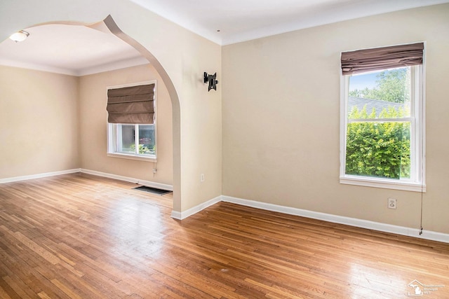 5369 Weddell St, Dearborn Heights, MI 48125 - empty room featuring arched walkways, wood-type flooring, and ornamental molding